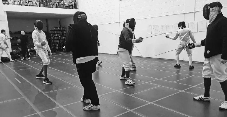 A group of fencers receiving coach training