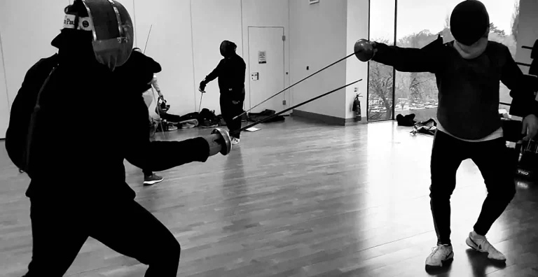 A fencing coach instructing a trainee